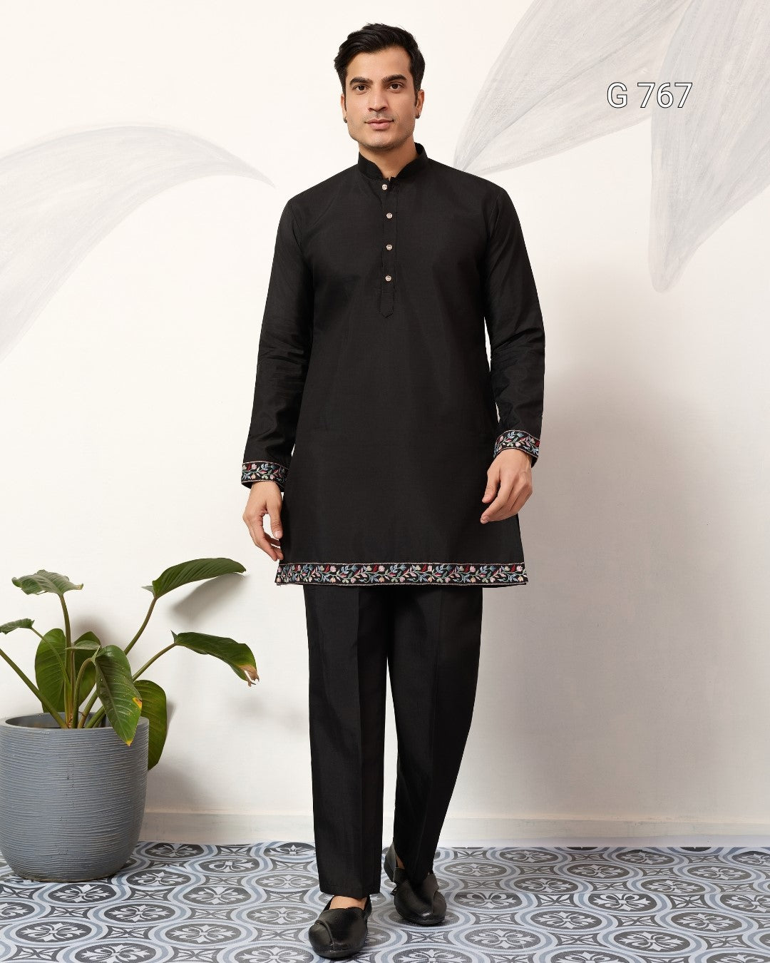 Man wearing a black kurta with a white background