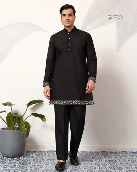 Man wearing a black kurta with a white background