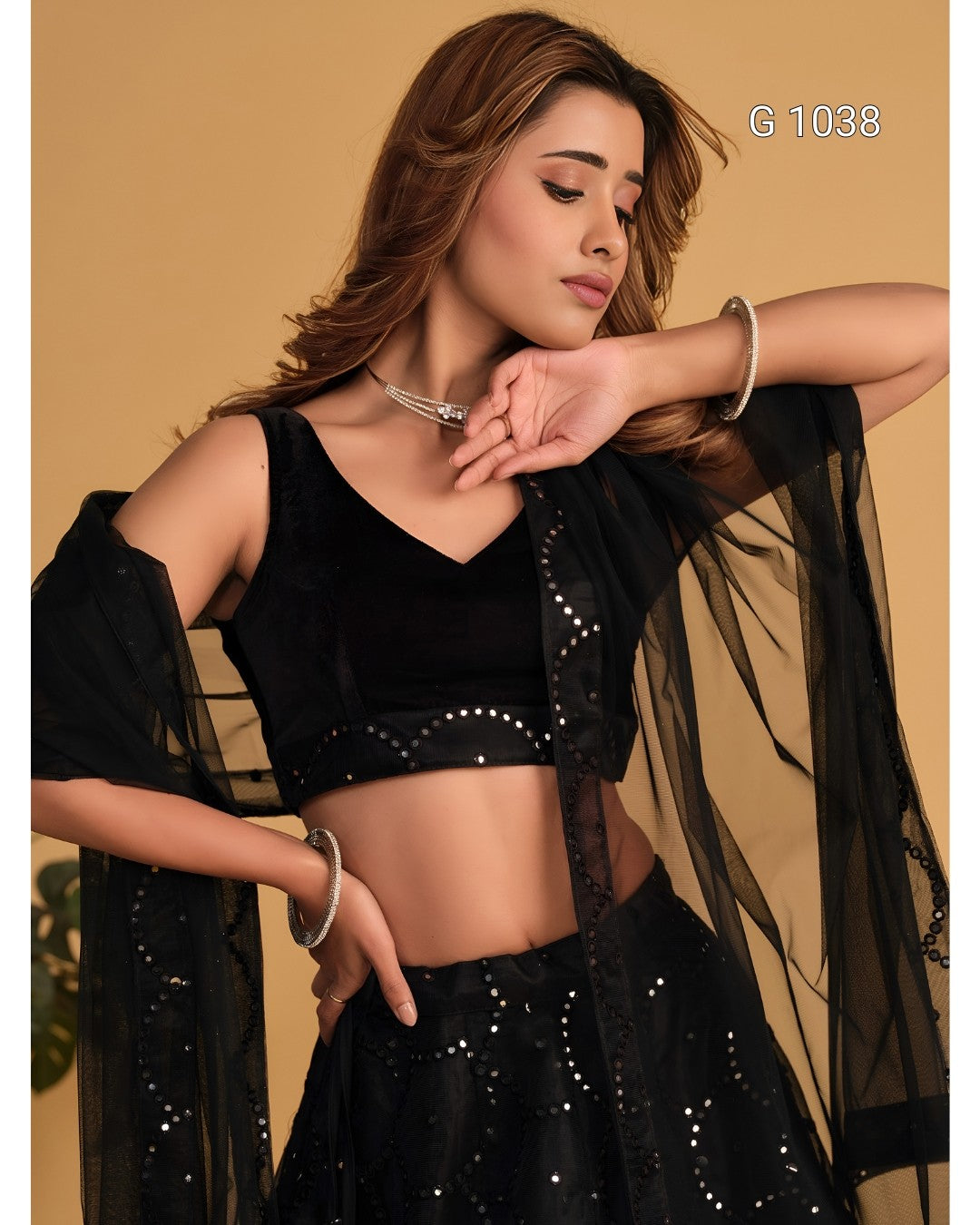 A woman modeling a black embroidered and embellished traditional outfit with a sheer black dupatta, set against a solid beige background. The text 'G 1038' is visible in the top right corner.