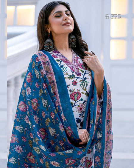 Woman wearing a floral dress with a blue dupatta in an indoor setting