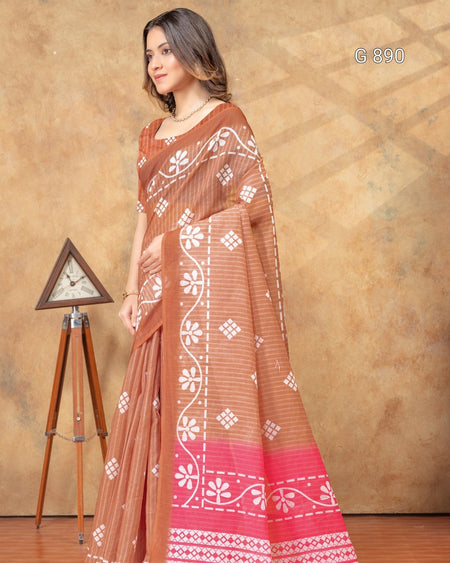 Woman wearing a brown saree with white patterns against a beige background