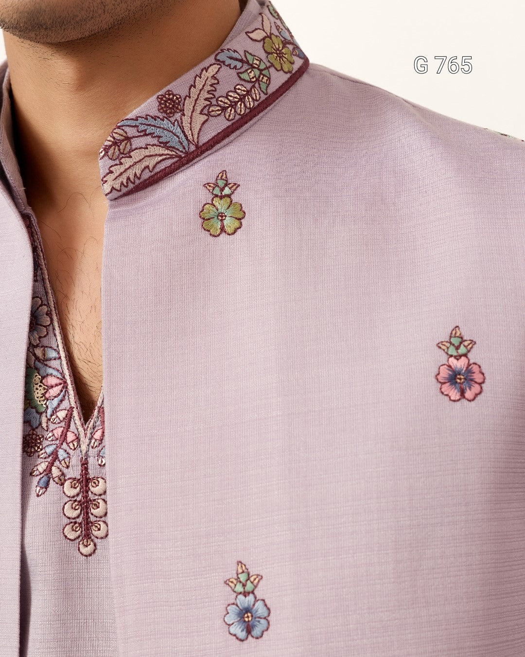 Close-up of a light purple shirt with floral embroidery on a white background