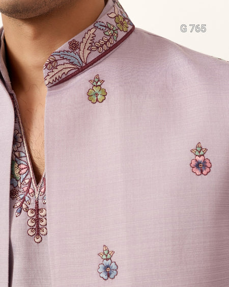 Close-up of a light purple shirt with floral embroidery on a white background