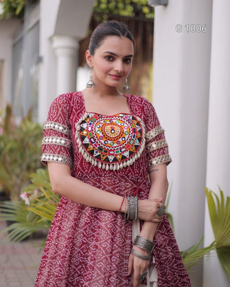 A woman wearing a red printed kurta with a large multicolor embroidered mandarin collar and patterned short sleeves, standing outdoors in front of white columns.