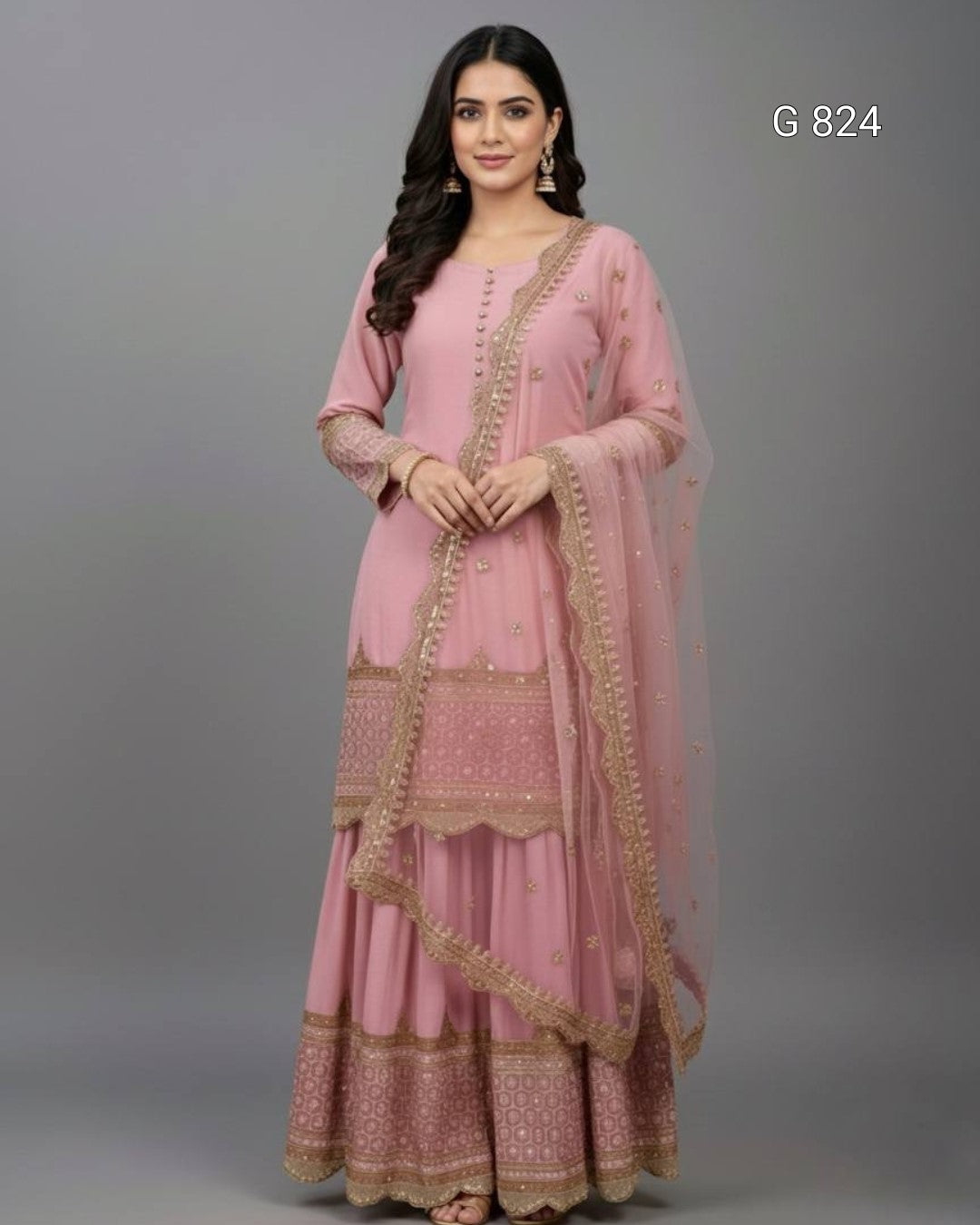 Woman wearing a pink traditional outfit with gold embroidery on a gray background