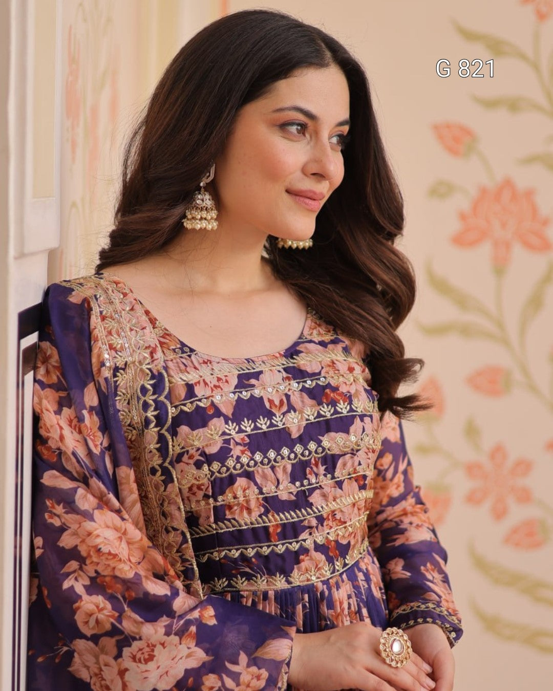 Woman wearing a floral dress with jewelry against a floral background