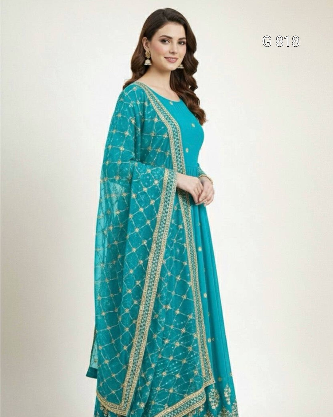 Woman wearing a teal saree with gold patterns on a white background