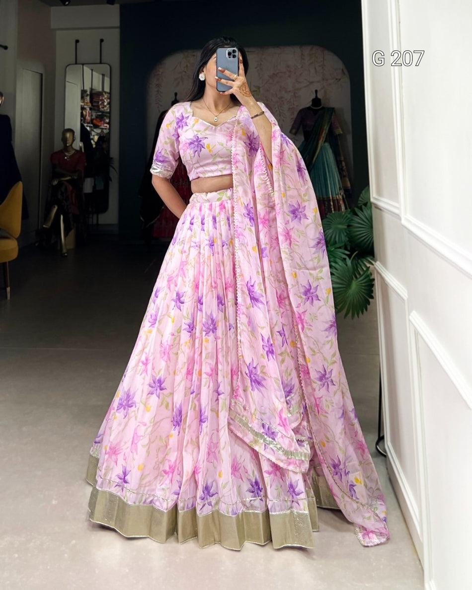 Person wearing a pink floral saree with a matching blouse in a room.