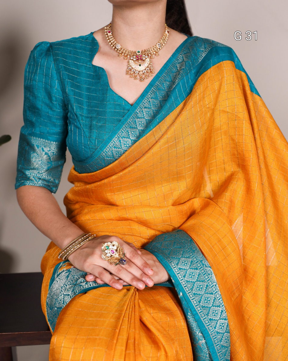 Woman wearing a traditional orange saree with blue border and jewelry.