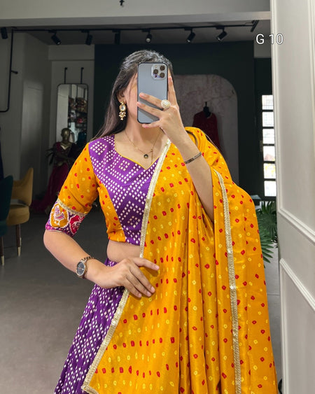 Person wearing a vibrant yellow and purple traditional outfit with a saree, taking a mirror selfie.