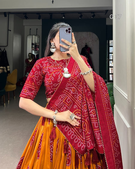 Person wearing a red and orange traditional outfit with a patterned shawl, taking a mirror selfie.