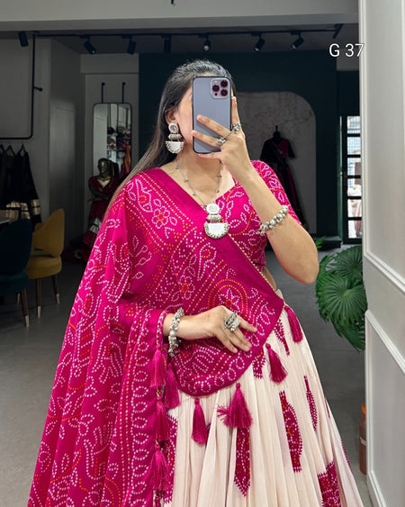 Person wearing a pink and white traditional outfit with jewelry, taking a mirror selfie.