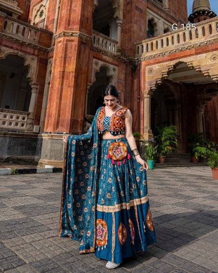Woman in a blue traditional outfit standing in front of an architectural building.