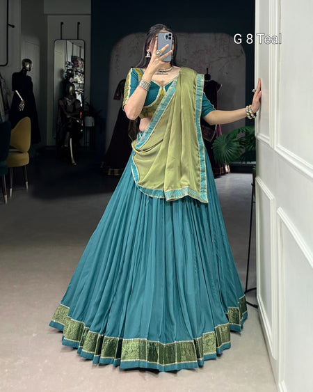Person wearing a blue and green traditional outfit taking a mirror selfie.
