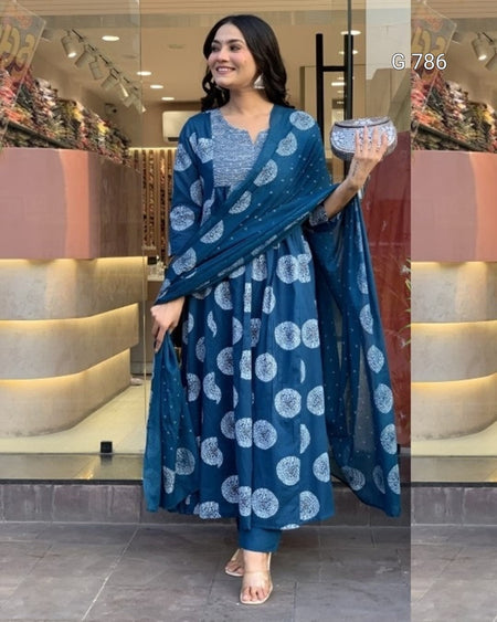 Woman in a blue patterned outfit holding a clutch in a store setting