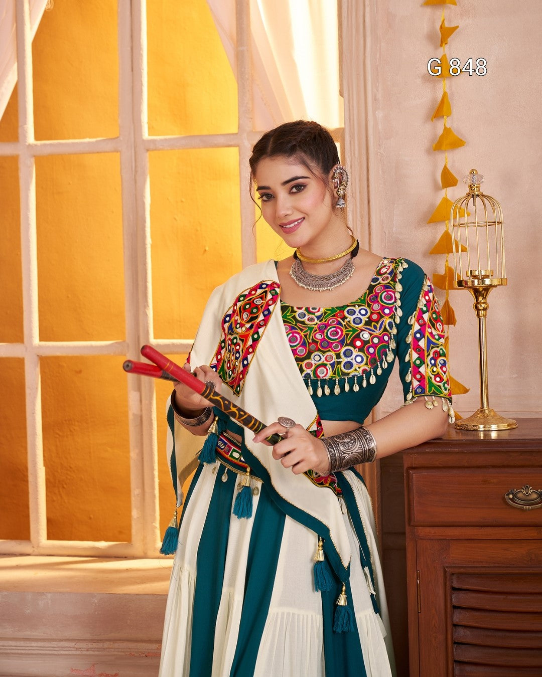 Woman in traditional outfit with colorful jewelry and a decorative item, indoors.