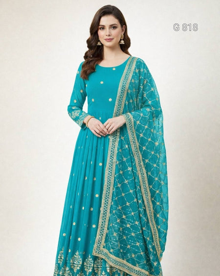 Woman wearing a teal traditional outfit with a matching dupatta on a white background