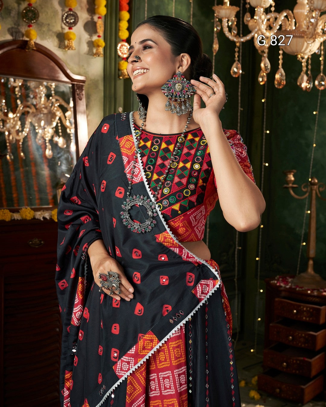 Woman in traditional attire with intricate jewelry in a decorated room.
