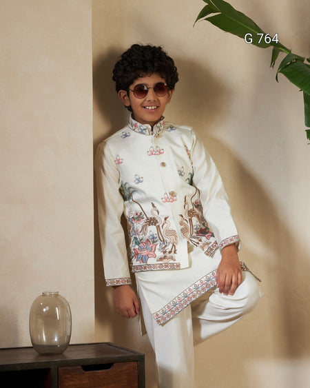 Young boy wearing a traditional embroidered outfit with sunglasses, standing against a beige wall.