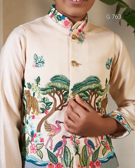 Beige embroidered shirt with colorful designs of animals and nature, held by a person.