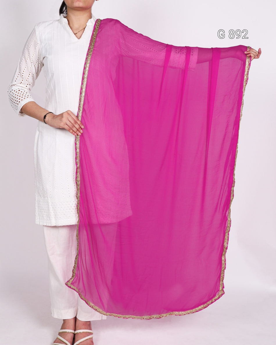 Person holding a bright pink dupatta with a white background