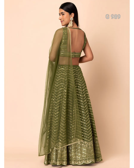 An olive green embroidered lehenga choli set with a sheer dupatta, shown on a model from the back against a solid beige background.