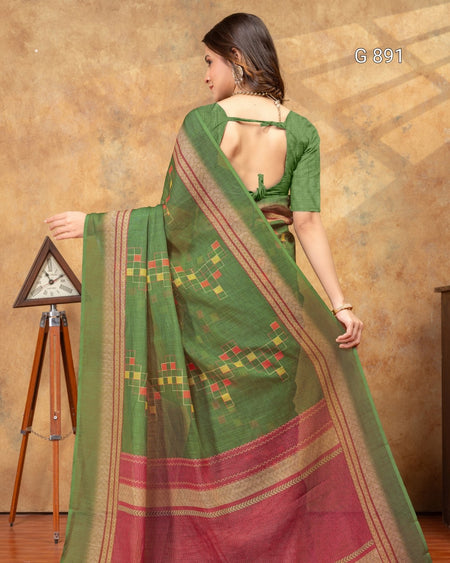Woman wearing a green and red saree with a brown background