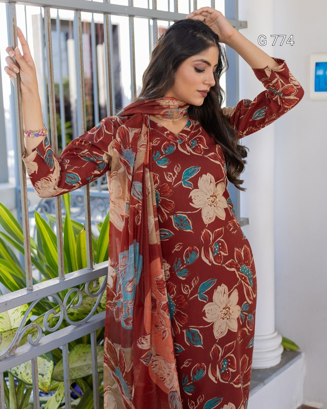 Woman wearing a floral patterned dress standing outdoors.