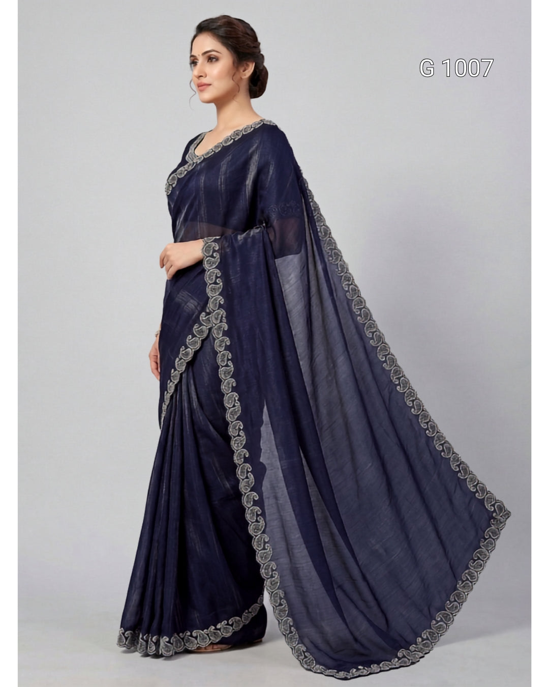 A woman modeling a navy blue saree with silver embroidered borders, standing against a light gray studio background. The text 'G 1007' appears in the top right corner.