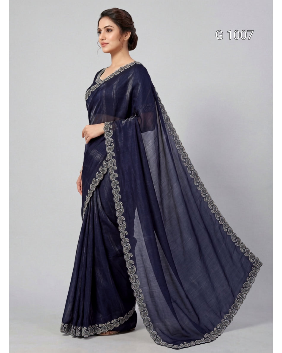 A woman modeling a navy blue saree with silver embroidered borders, standing against a light gray studio background. The text 'G 1007' appears in the top right corner.