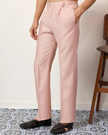 Person wearing light pink pants with a white background