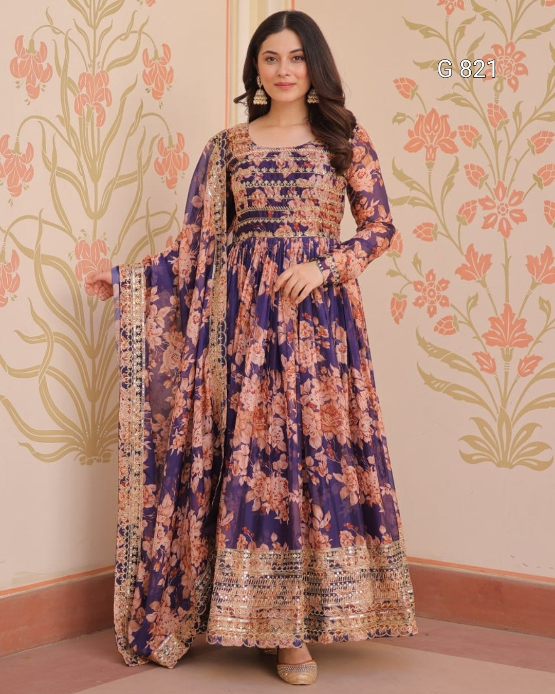 Woman wearing a floral dress with a decorative wall in the background