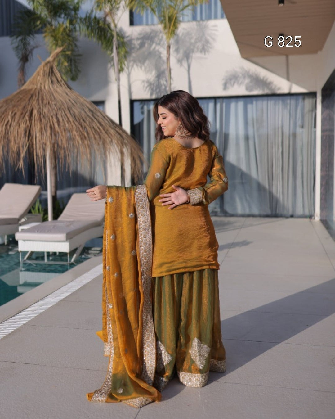 Woman in mustard yellow traditional outfit by a poolside