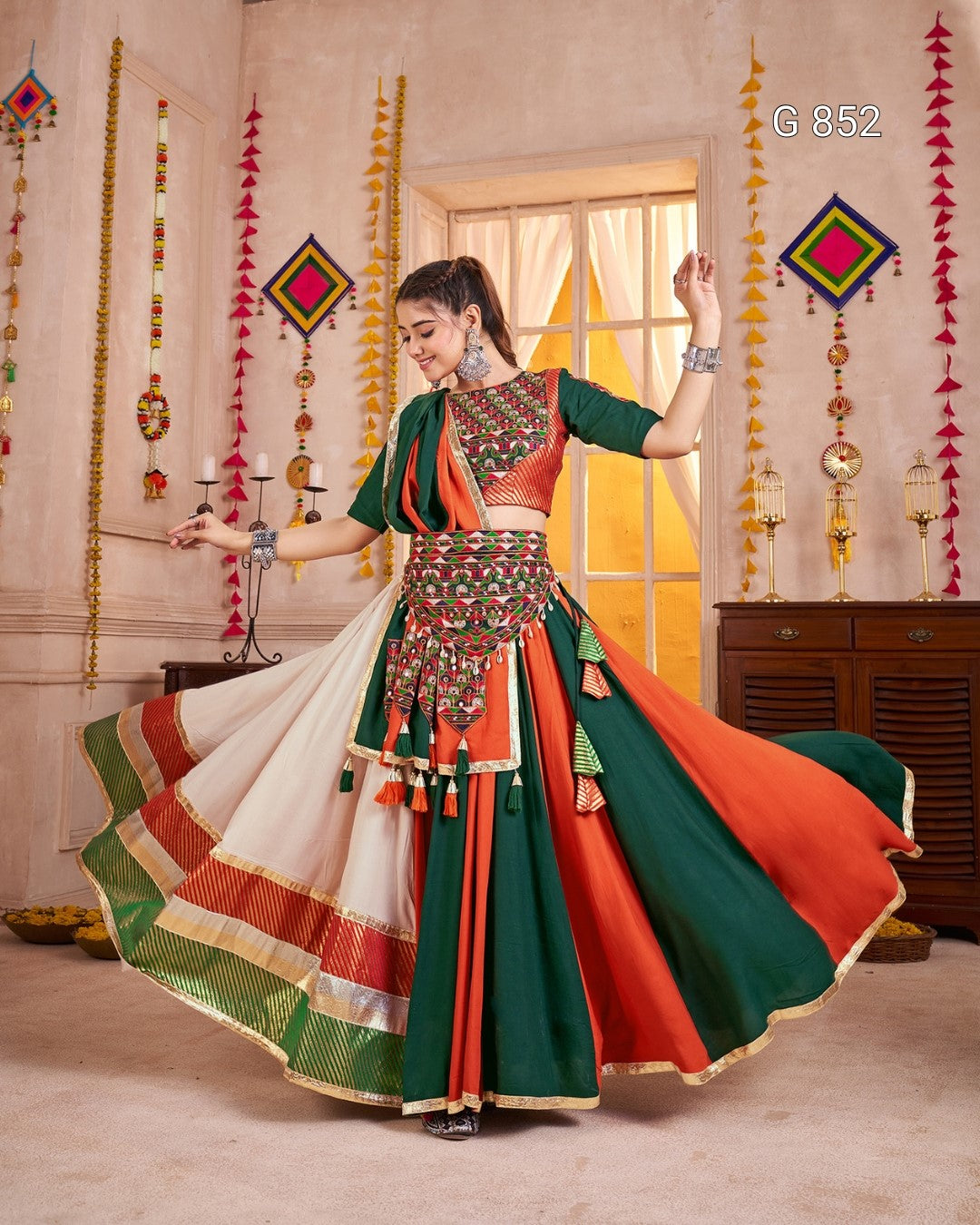 Woman in a traditional outfit with vibrant colors dancing in a decorated room.