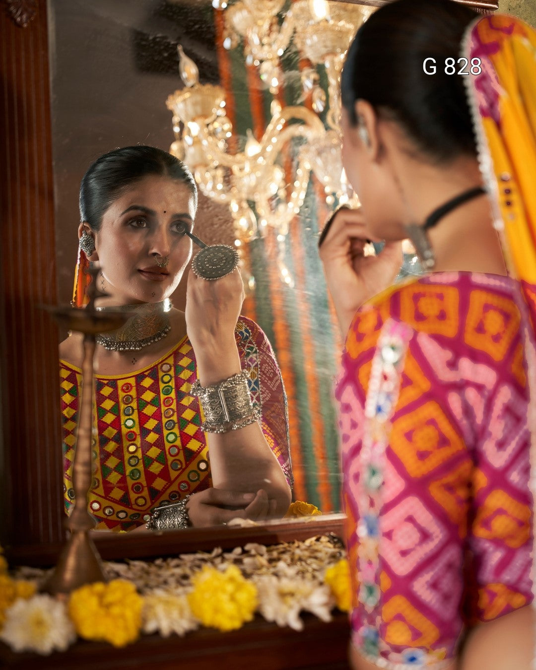 Woman applying makeup in front of a mirror with decorative elements.
