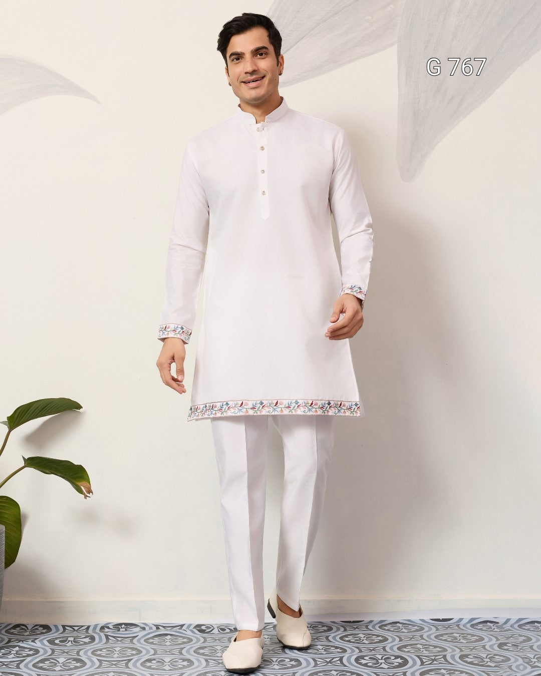 Man wearing a white kurta with pants in a minimalistic setting