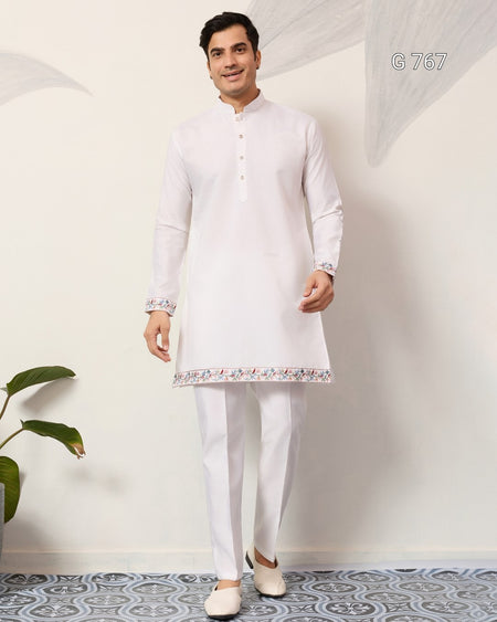 Man wearing a white kurta with pants in a minimalistic setting