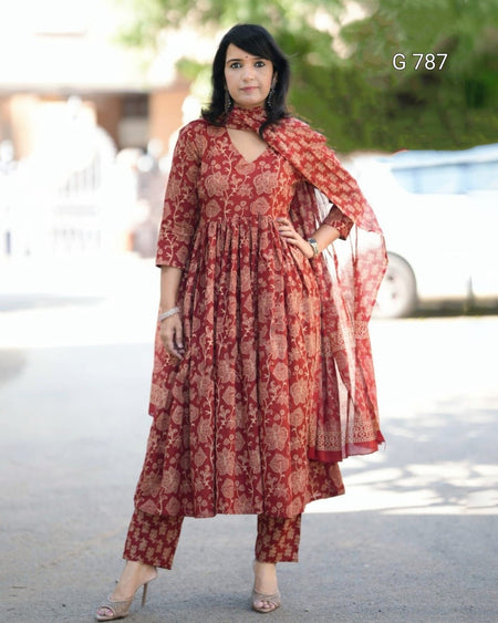 Woman wearing a red patterned dress with a scarf in an outdoor setting