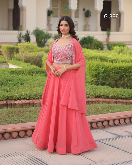 Woman in a pink traditional outfit standing in a garden setting