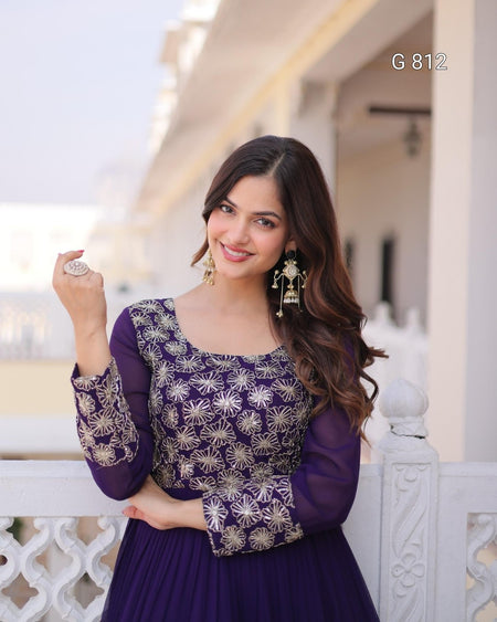 Woman wearing a purple dress with floral patterns in an outdoor setting
