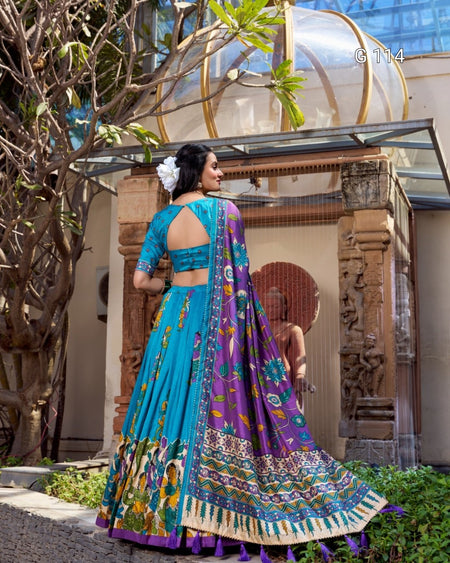 Woman in a colorful traditional outfit standing outdoors with decorative elements in the background