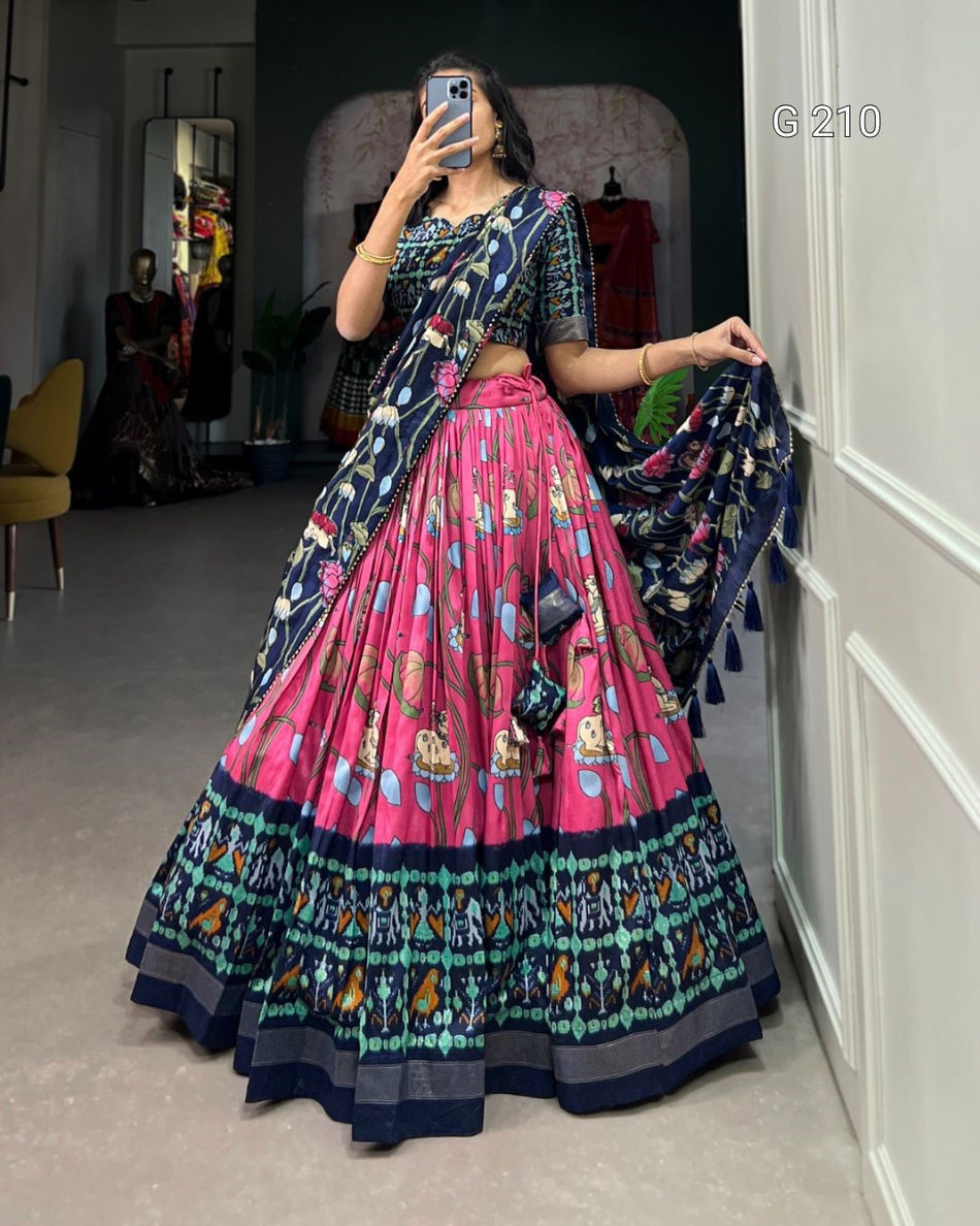 Person wearing a colorful traditional outfit with a patterned skirt and top, standing in a room.