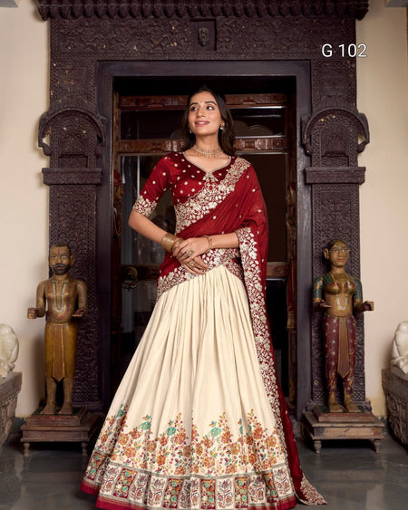 Woman in a red and white traditional outfit standing in a decorated room with statues.