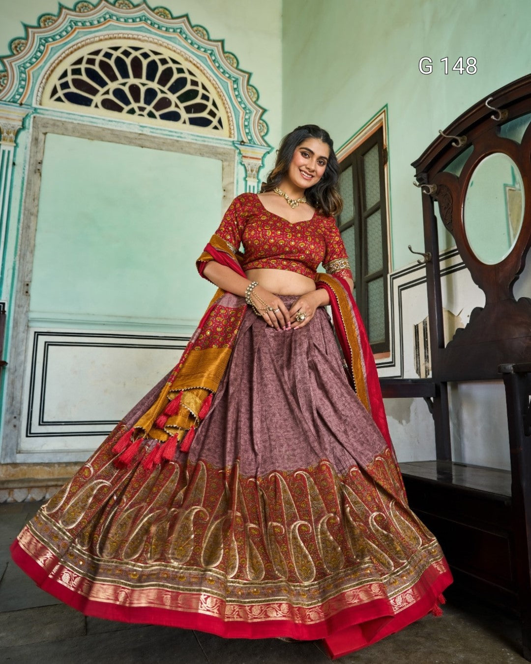 Woman wearing a traditional red and gold lehenga in an indoor setting