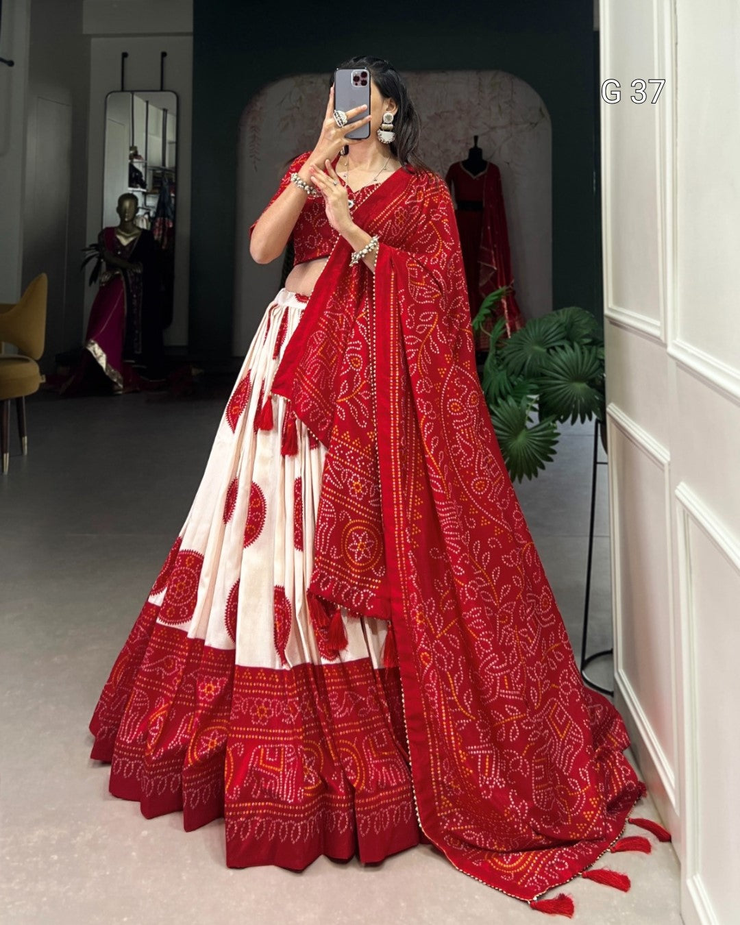 Person wearing a red and white traditional outfit with a matching dupatta, standing in a room.