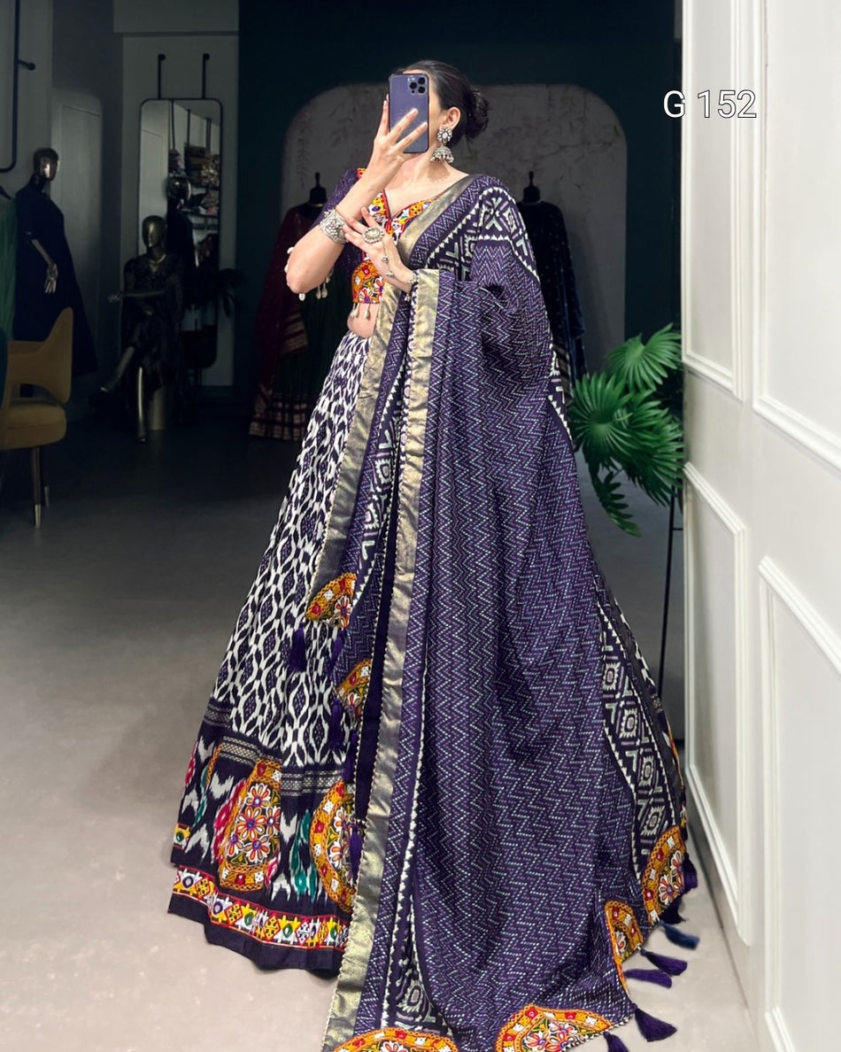 Person wearing a traditional outfit with a patterned dress and scarf in a room.