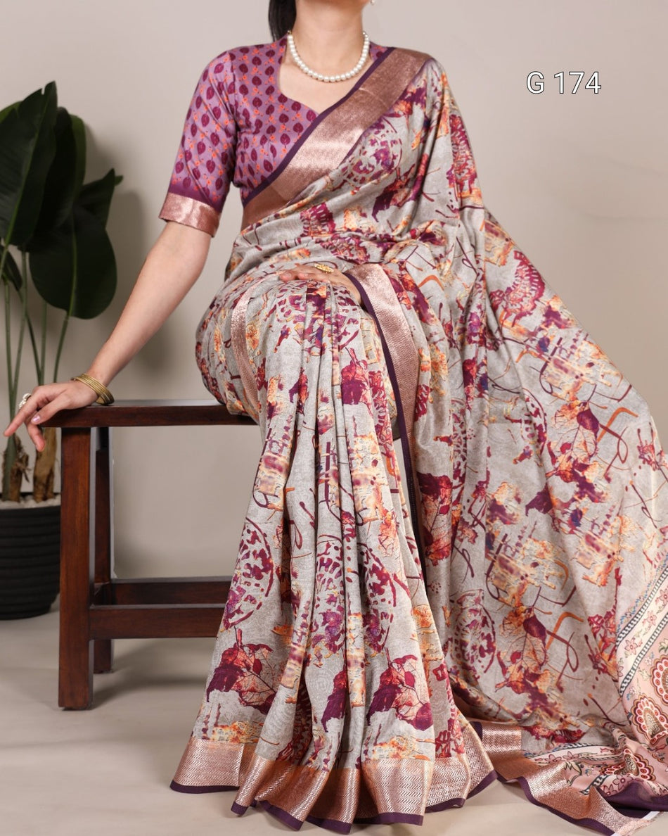 Woman wearing a colorful saree with a patterned blouse, sitting on a wooden stool.