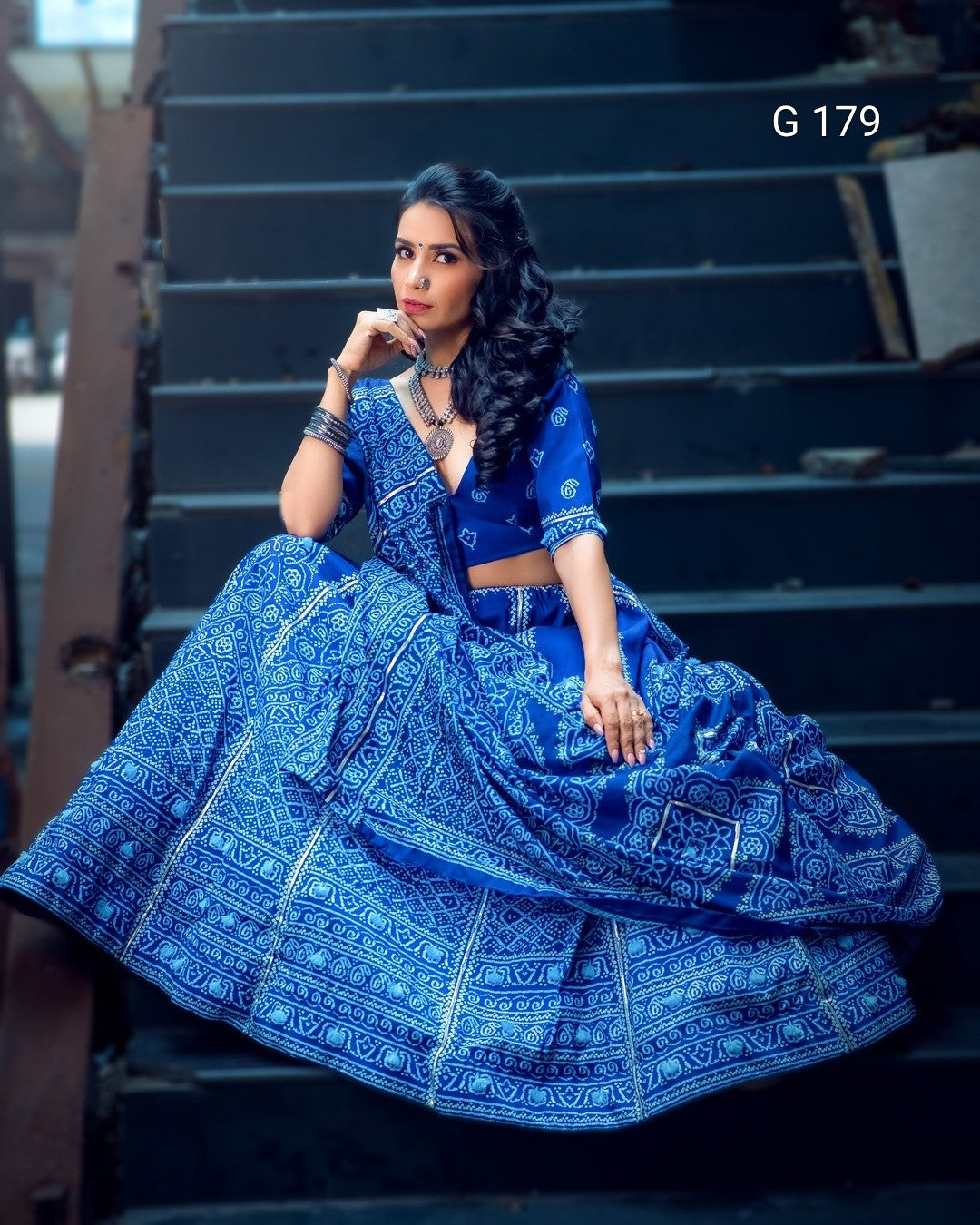 Woman in a blue traditional outfit sitting on steps