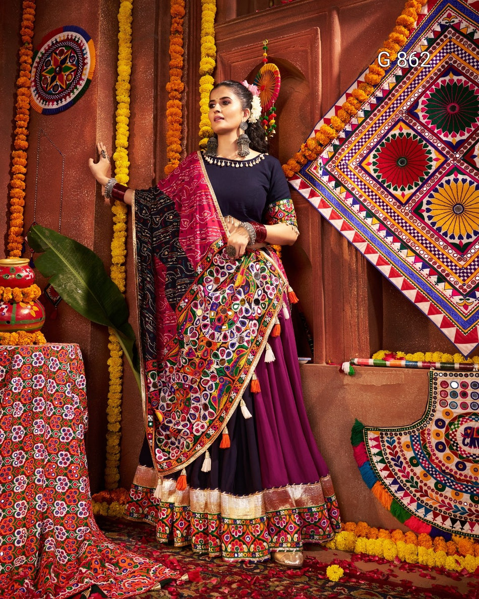 Woman in traditional attire standing in a decorated room with colorful patterns and decorations.