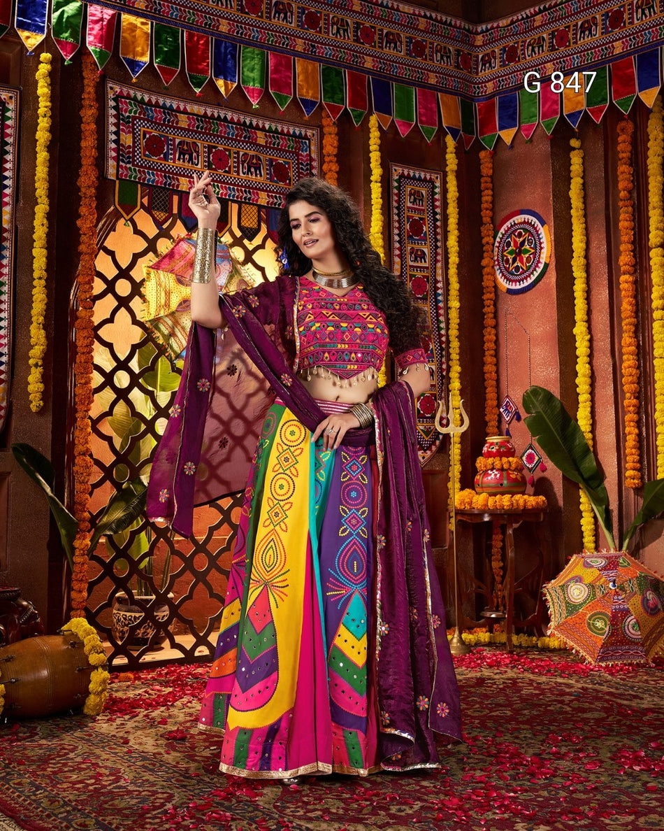 Woman in a colorful traditional outfit standing in a decorated room with vibrant patterns and decorations.